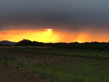 Scenic view of field against sky during sunset