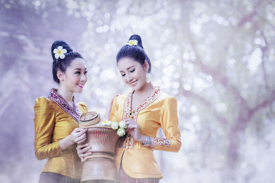 Women wearing traditional clothing with flowers standing outdoors