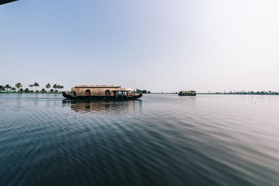 Houseboat in lake against clear sky