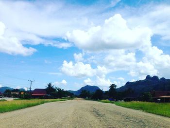 Road amidst field against sky