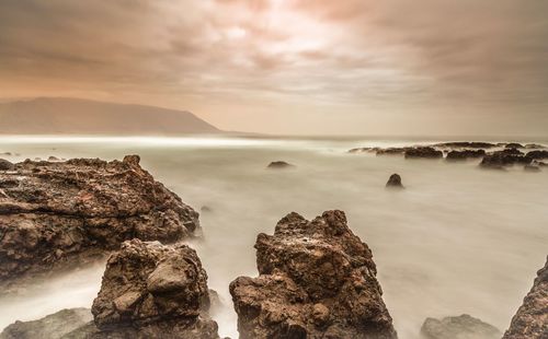 Scenic view of sea and rock formations against sky