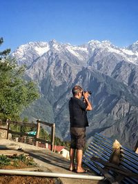 Full length of man photographing while standing on mountain