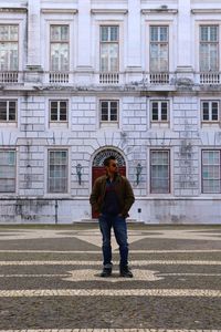 A young man in jacket and sunglasses standing