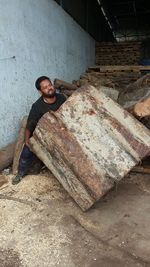 Man lifting wood at storage room