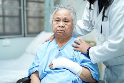 Midsection of doctor caring patient in hospital