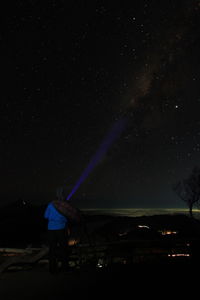 Rear view of man standing against star field at night. milky way