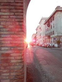 Street amidst buildings against sky during sunset