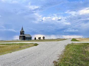 Road amidst buildings against sky