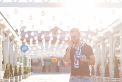 Full length of young man using mobile phone