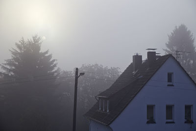 Low angle view of houses against clear sky during winter