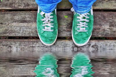 Low section of man standing by lake