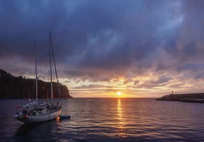 Sailboats sailing on sea against sky during sunset