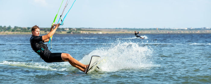 Man surfing in sea against sky