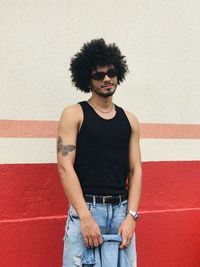 Portrait of young man standing against wall