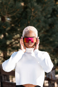 A young african american woman wearing sunglasses having fun in the snow on a winter day