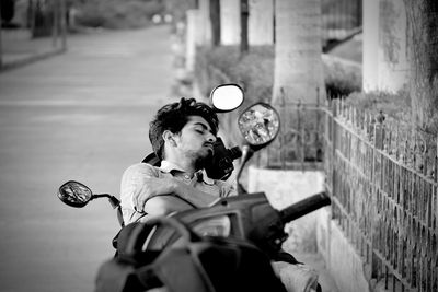 High angle view of young man sleeping on motor scooter