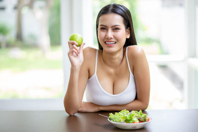 Young woman eating food on table