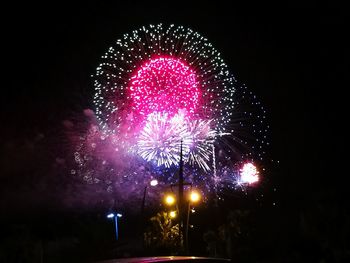 Low angle view of firework display at night