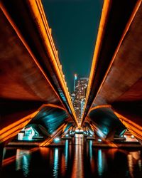 Low angle view of illuminated bridge in city at night