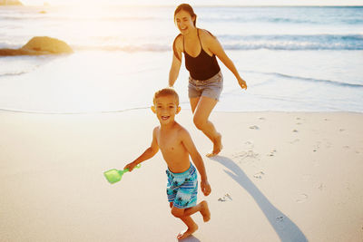 Mother and son running at beach