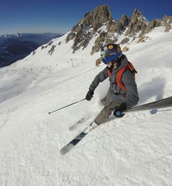 Boy taking selfie with monopod while skiing on snow covered landscape