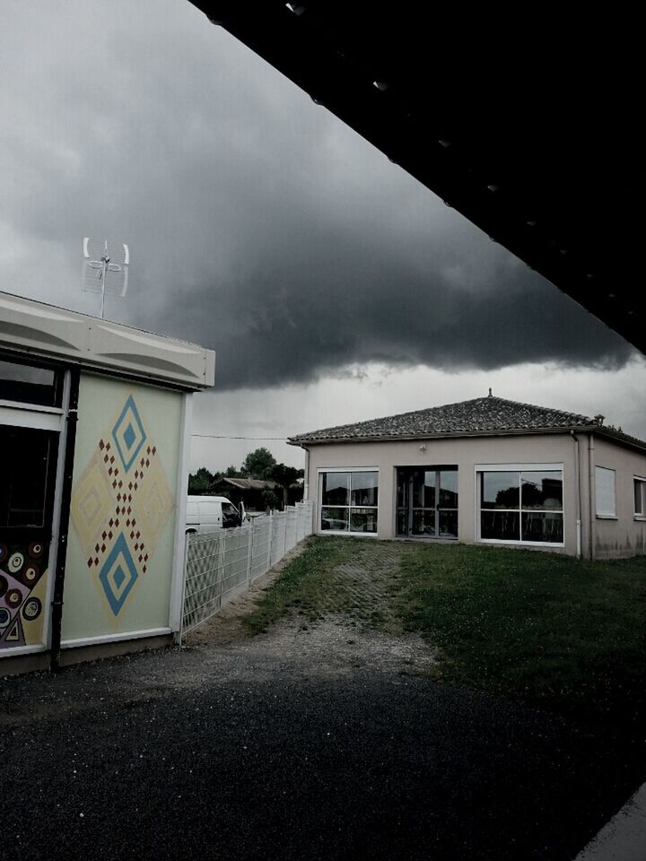 architecture, building exterior, sky, built structure, cloud - sky, street, cloudy, road, the way forward, house, cloud, residential structure, residential building, weather, no people, empty, outdoors, day, transportation, overcast