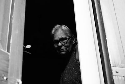 Portrait of woman looking through window