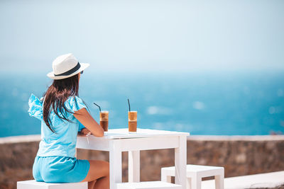 Rear view of woman looking at sea against sky