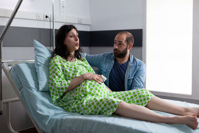 Man with pregnant woman sitting at hospital