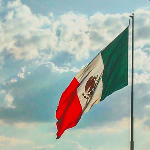 LOW ANGLE VIEW OF FLAGS AGAINST CLOUDY SKY