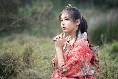 Girl looking away while standing on field