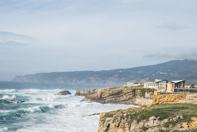 Coastline with atlantic ocean in cascais, portugal. waves at the shore and rocky hills