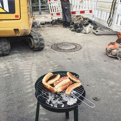 High angle view of sausages on barbecue at construction site