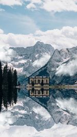 Scenic view of lake by snowcapped mountains against sky