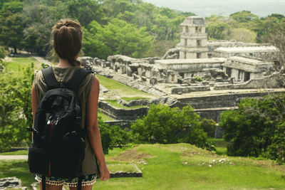 Rear view of woman standing against building