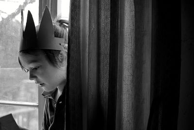 Portrait of boy looking through window