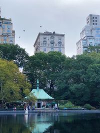 Buildings and trees in city against sky