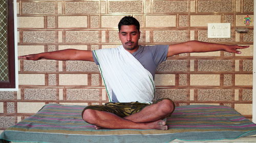 Portrait of young man making face against wall