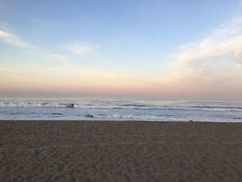 Scenic view of beach against sky during sunset