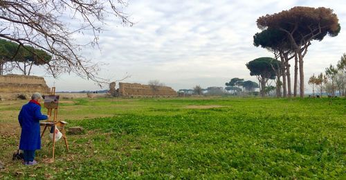 Rear view of man standing on grassy field