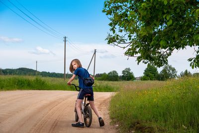 Full length of boy on road against sky