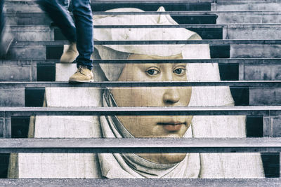 Low section of man walking on steps in city