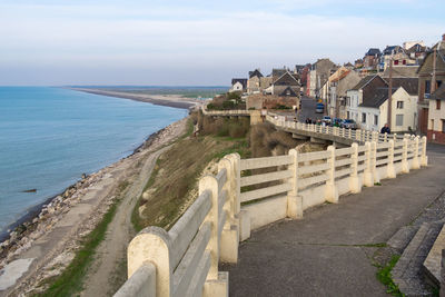 Buildings by sea against sky