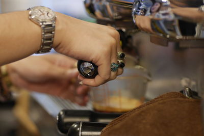 Cropped hand of woman filling coffee in cup