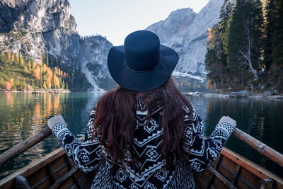 Rear view of woman looking at lake against mountain