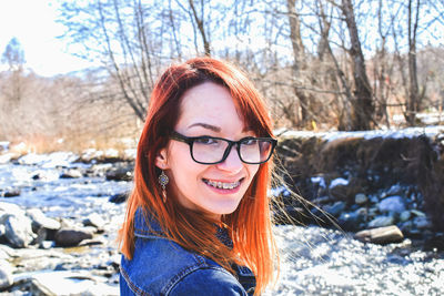 Portrait of a smiling young woman by river