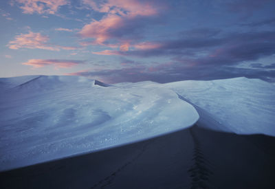 Scenic view of snowcapped mountains against sky during sunset
