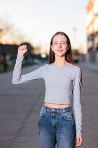 Portrait of smiling young woman standing against sea