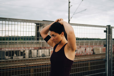 Young woman standing against railing