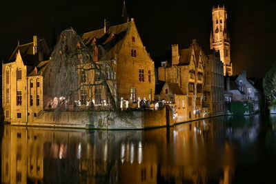 Reflection of buildings in lake at night